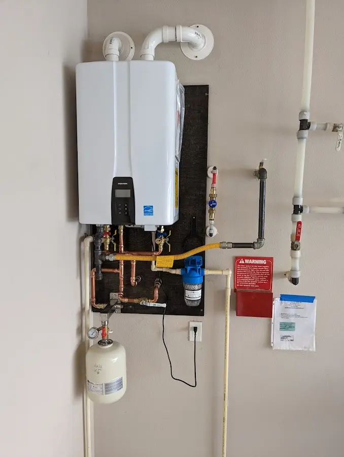 Professional plumber installing copper piping in a Salford home